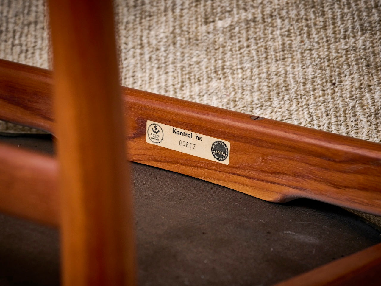 sticker met kontrol nr 817 op Danish Mid-Century stoel.  Kwaliteitslabel